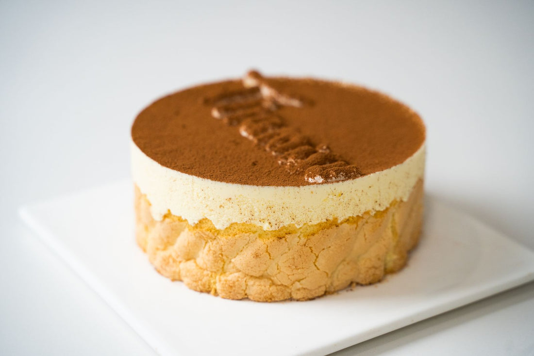 Tiramisu met een laag cacaopoeder op een wit bord