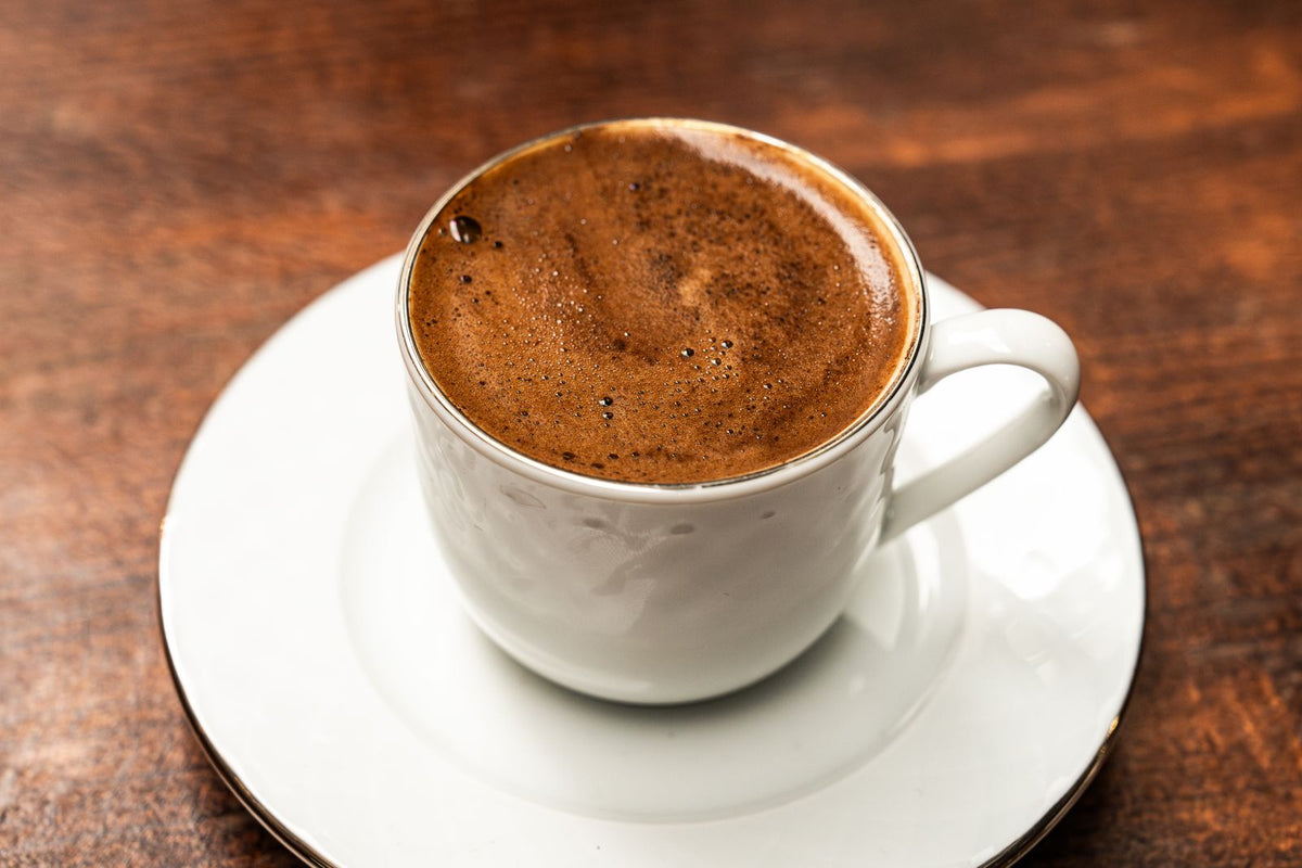 Kopje Turkse koffie met een dikke schuimlaag op een houten tafel