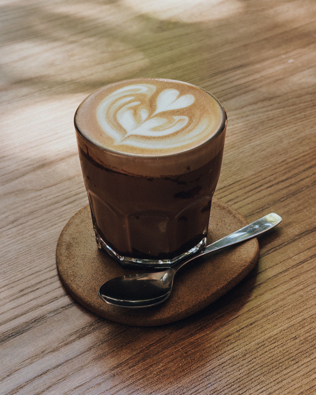 Flat white koffie met latte art op een houten tafel