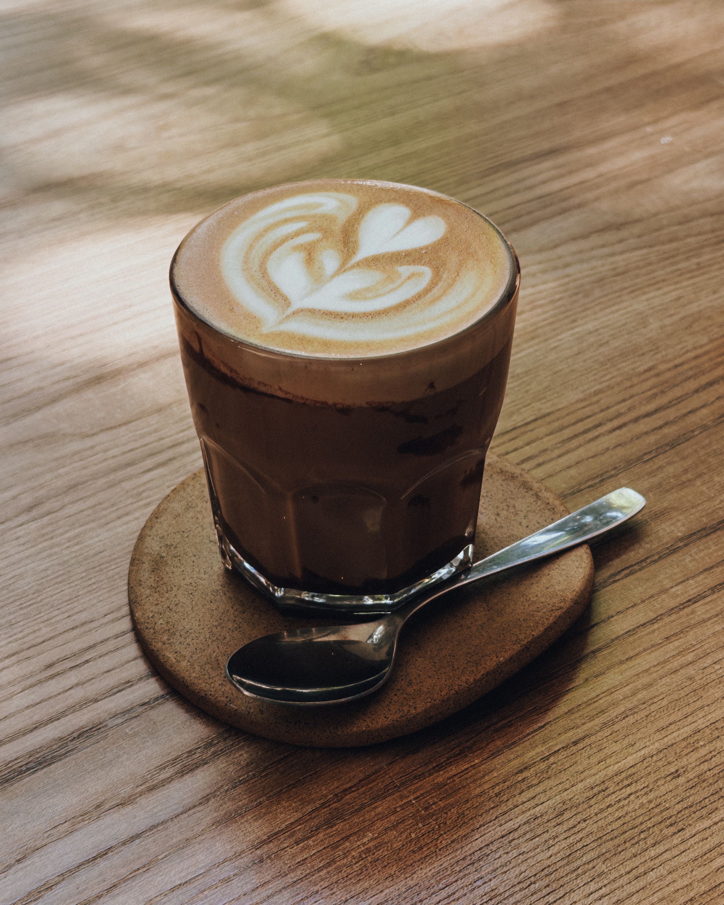 Flat white koffie met latte art op een houten tafel