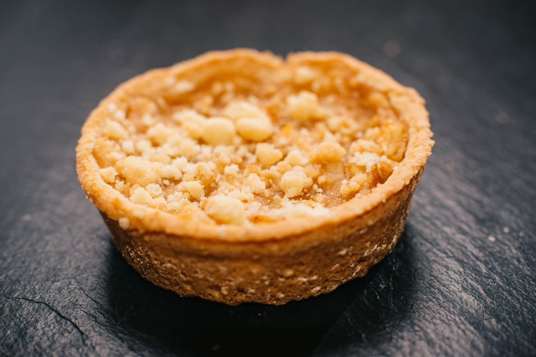 Appeltaart met kruimeldeeg op een donkere ondergrond