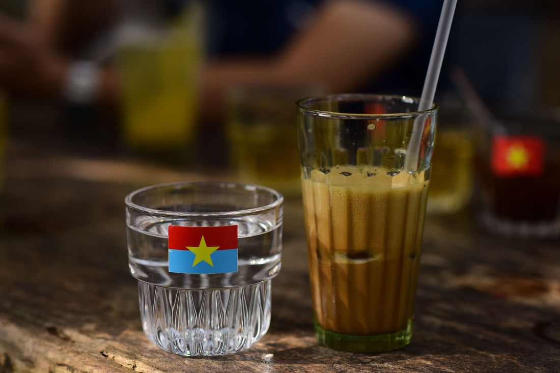 Glas Vietnamese ijskoffie met gecondenseerde melk en ijs op een houten tafel