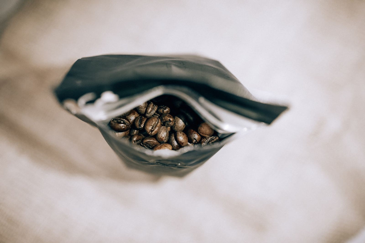 Een open zak koffiebonen zonder opdruk, met espressobonen erin