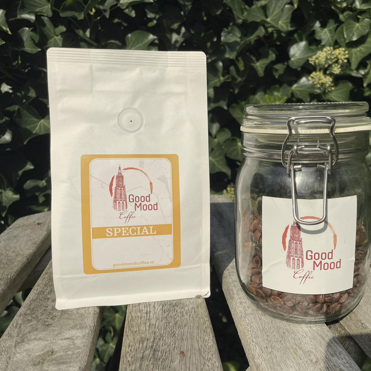 Close-up van de zak Wisselende Special van Good Mood Coffee en een glazen pot koffiebonen