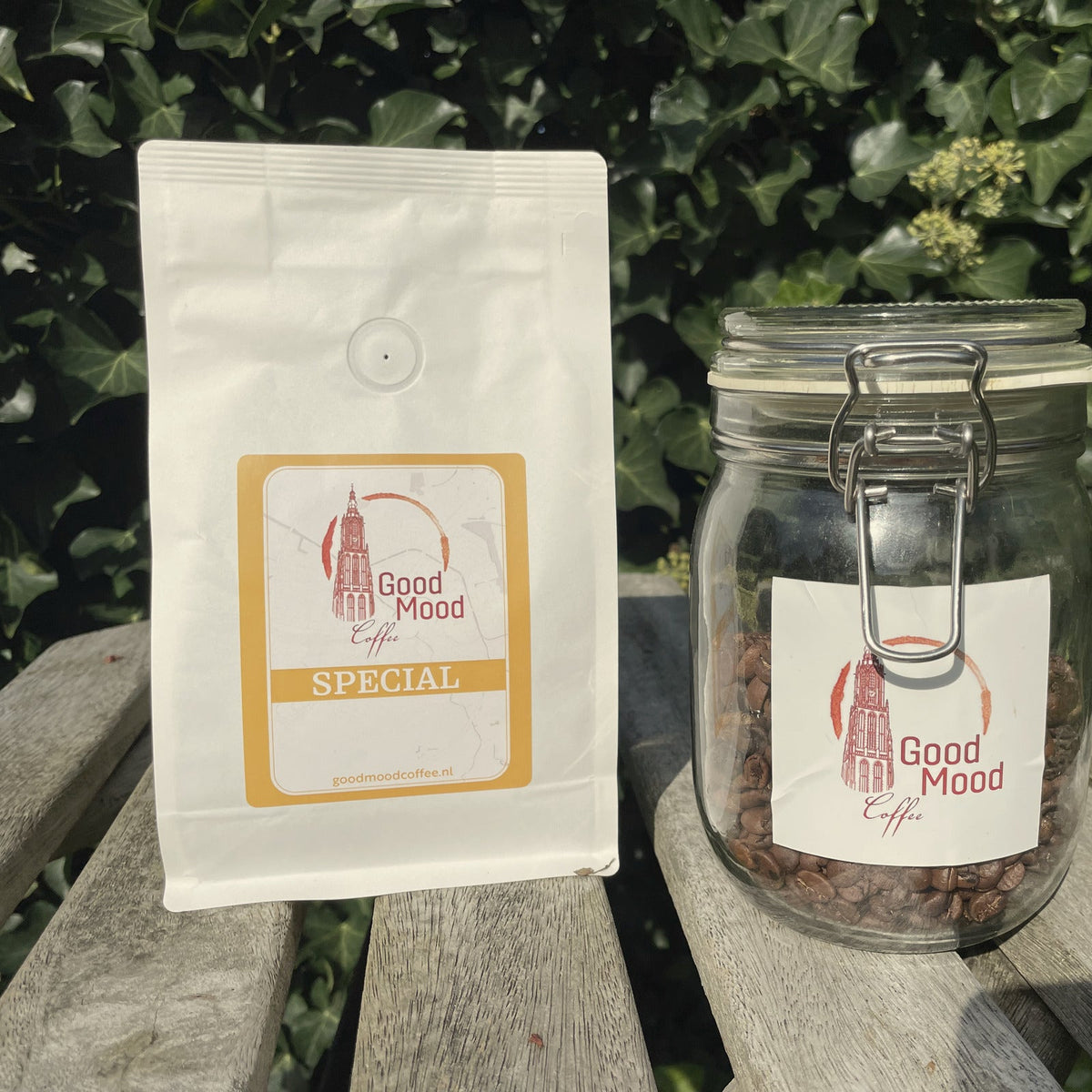 Close-up van de zak Wisselende Special van Good Mood Coffee en een glazen pot koffiebonen